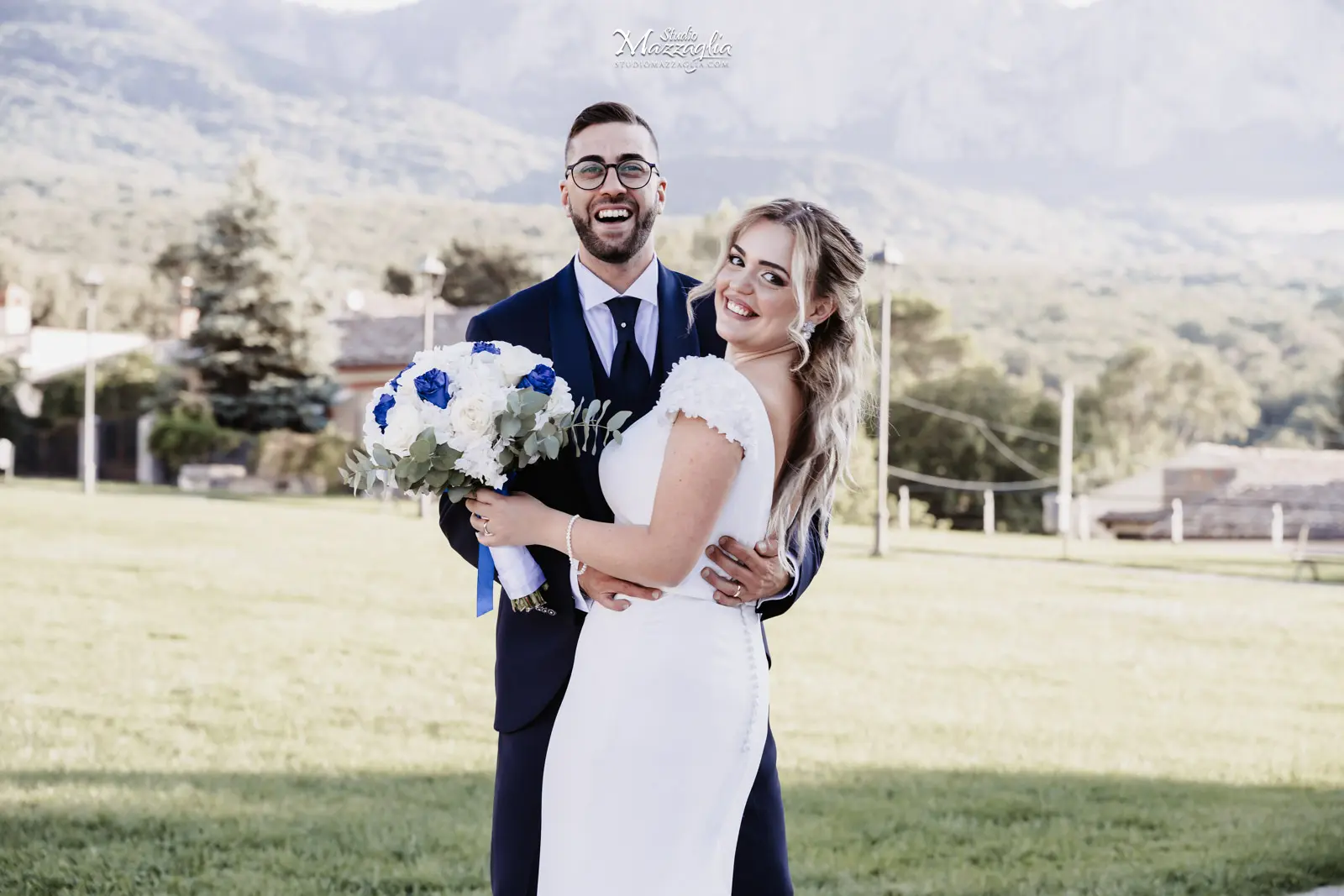 Servizio fotografico matrimonio Palermo: sposi Nicoletta e Pasquale sorridenti in un abbraccio all'aperto con montagne sullo sfondo