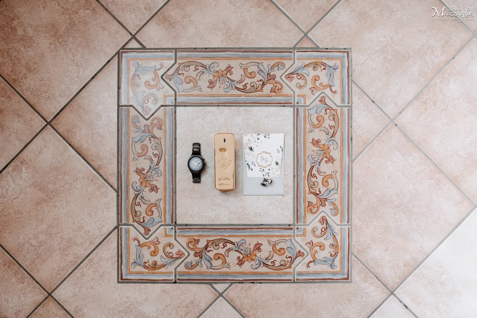 Dettaglio flat lay di accessori da sposo su pavimento in maiolica siciliana