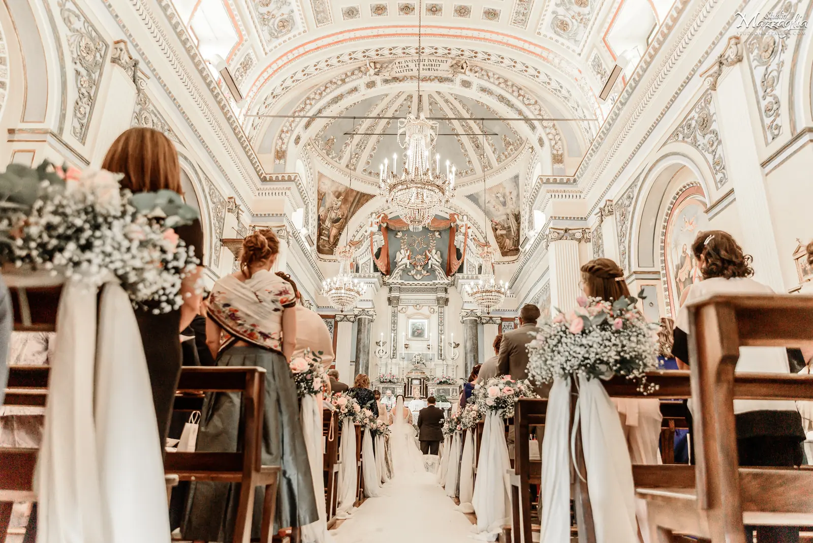 Cerimonia di matrimonio all'interno del Santuario di Tagliavia a Corleone, con vista sulla navata centrale allestita con fiori bianchi.