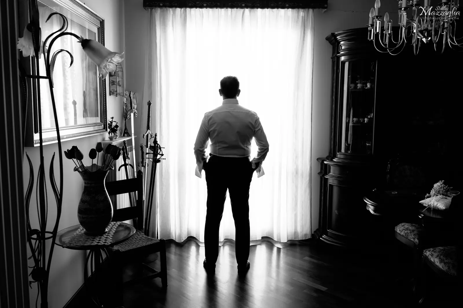 Sposo di spalle mentre guarda fuori dalla finestra