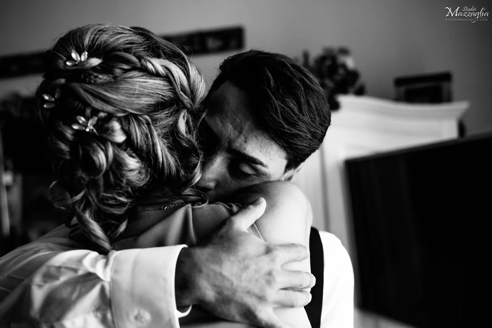 Abbraccio materno Un intenso momento in bianco e nero che ritrae lo sposo in un abbraccio commosso con la madre.