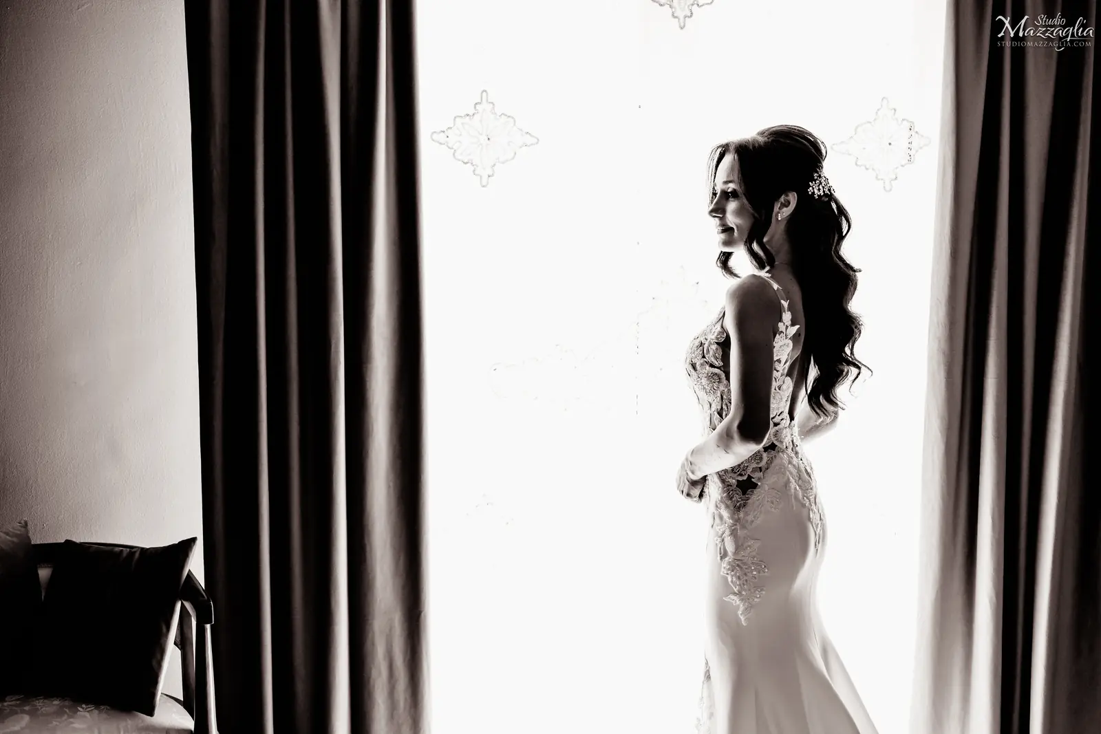 Ritratto sposa in luce Elegante ritratto in bianco e nero della sposa di profilo, in piedi davanti a una finestra luminosa.