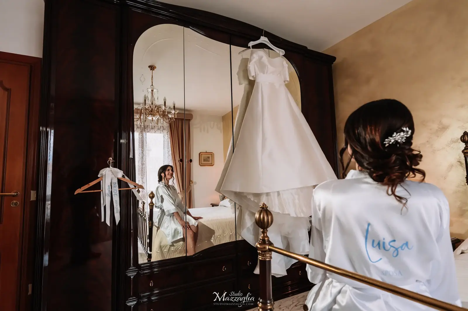 Abito da sposa appeso all'armadio e sposa di spalle