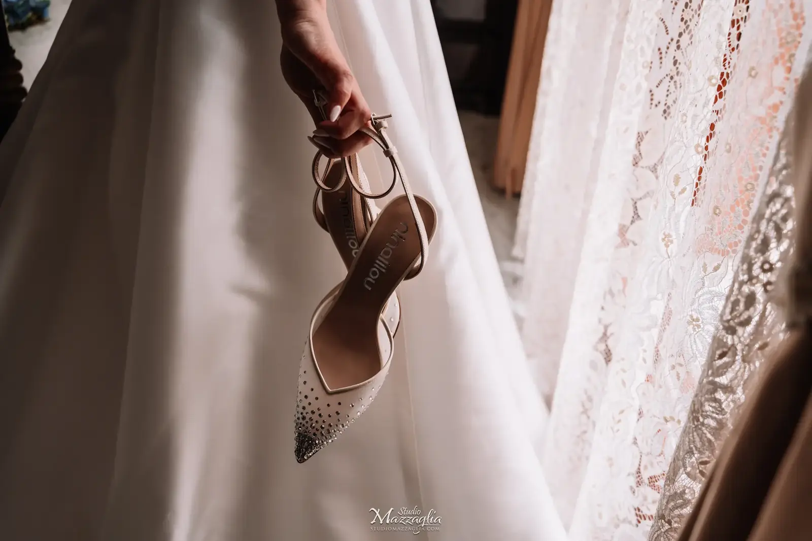 Sposa tiene in mano le scarpe con tacco glitterate