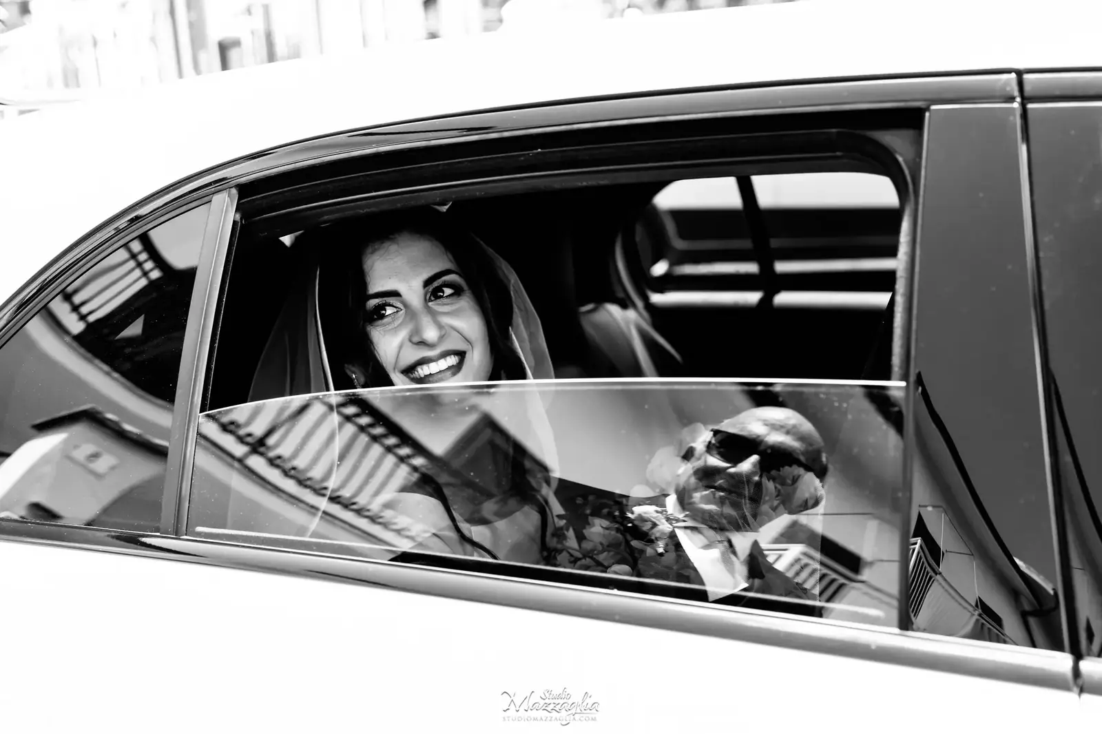 Sposa Luisa sorridente dentro l'auto nuziale