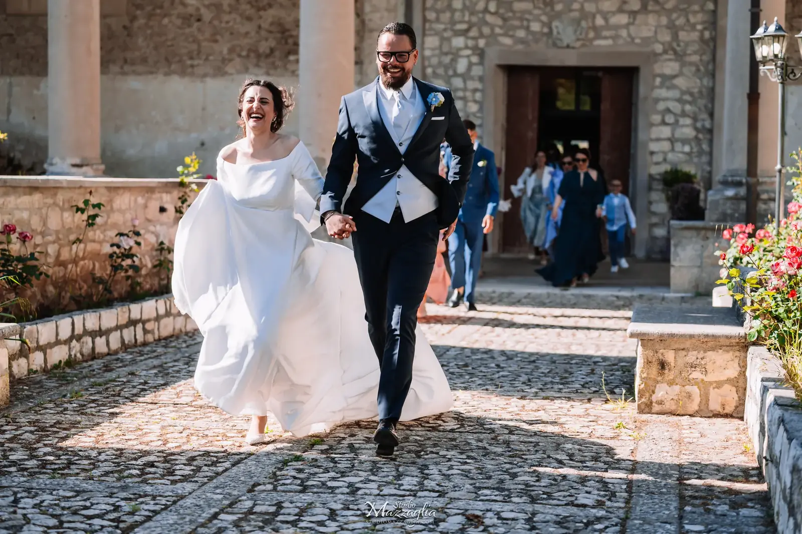 Sposi passeggiano felici mano nella mano nel borgo antico