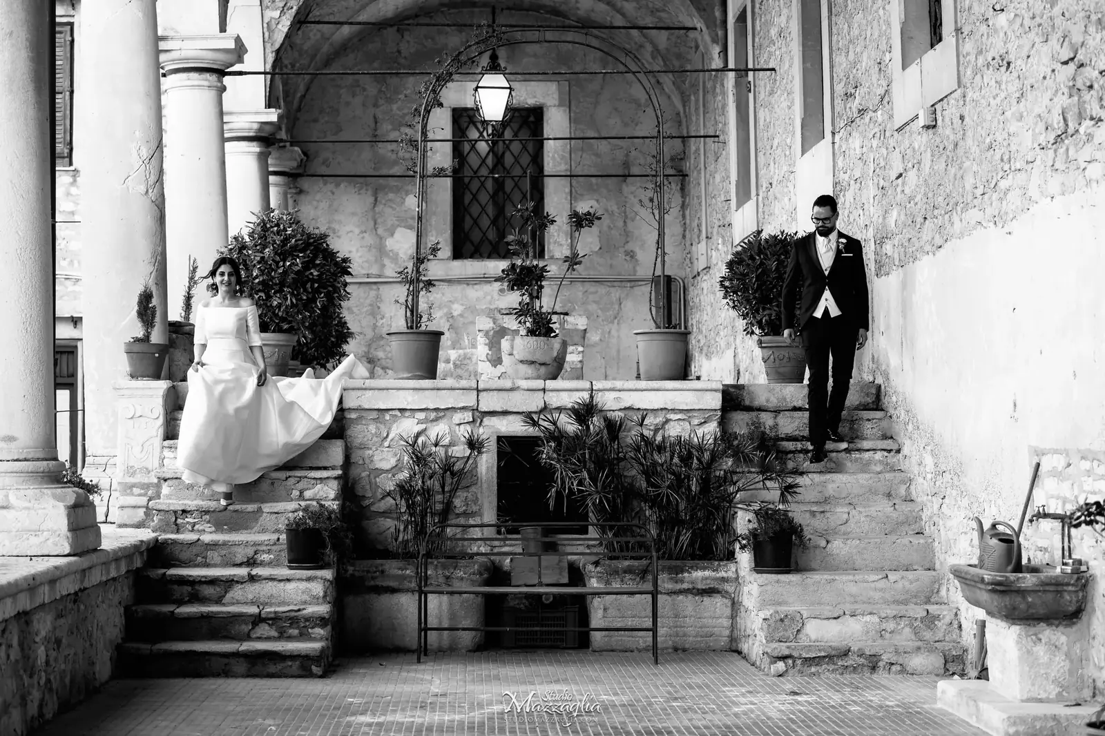Sposa scende una scalinata antica in bianco e nero