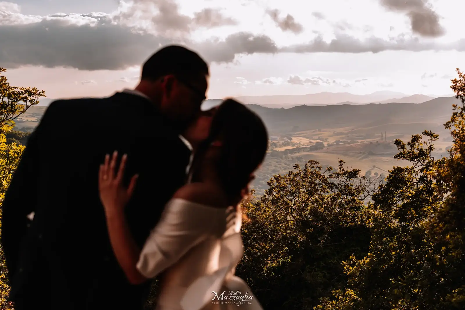 Silhouette degli sposi che si baciano al tramonto sui monti