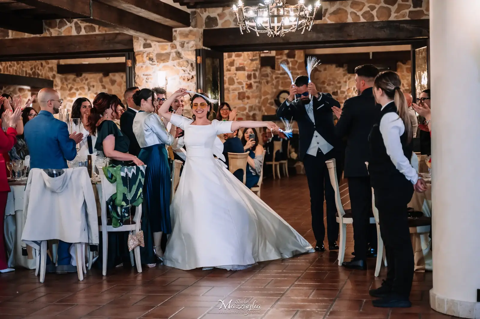Sposi ballano felici circondati dagli invitati in sala