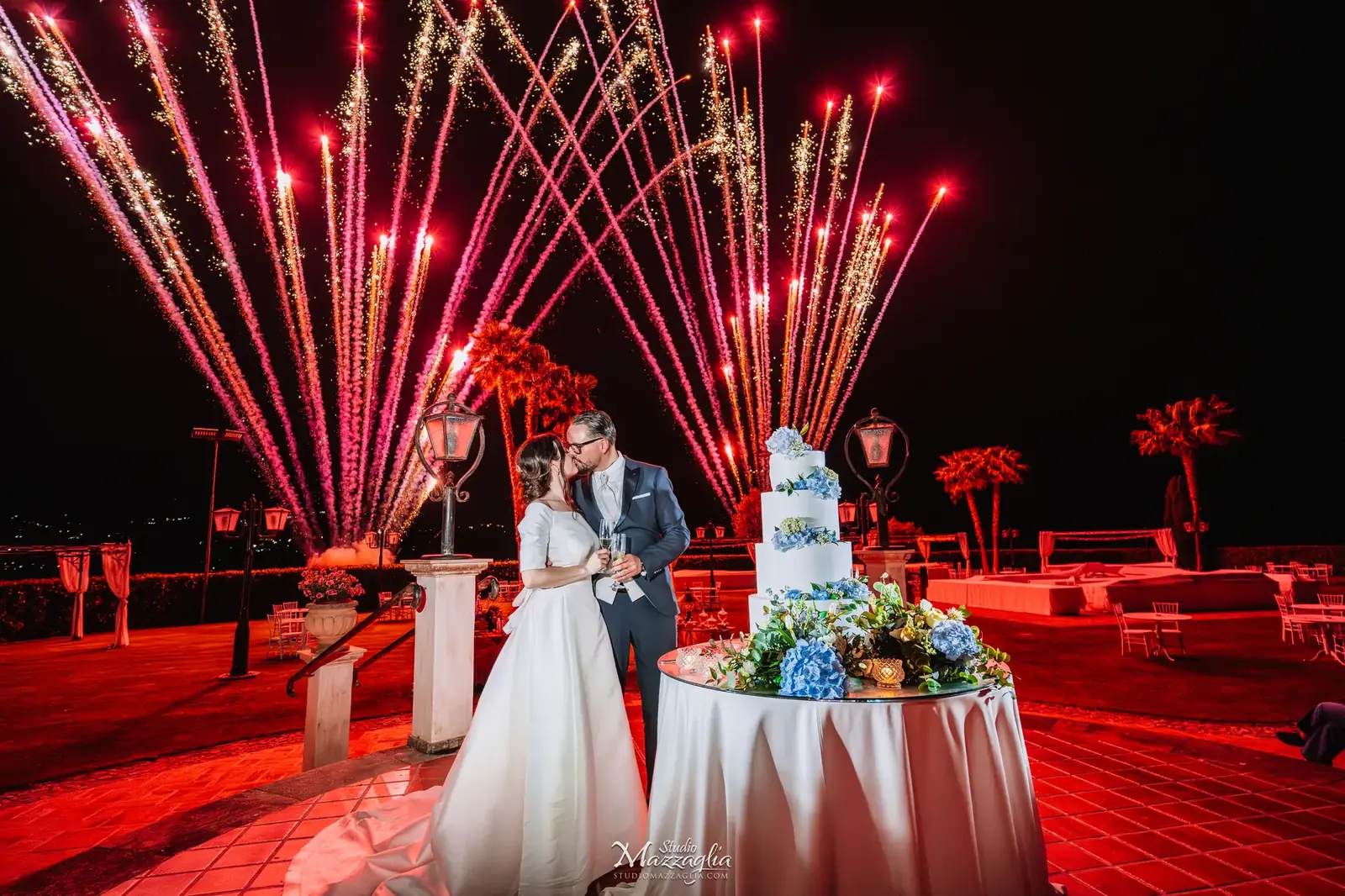 Taglio della torta nuziale monumentale con fuochi d'artificio rossi